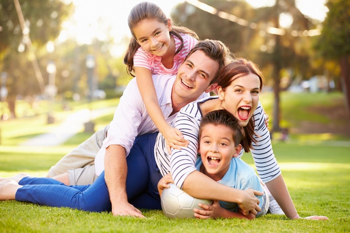 Financial Adviser Perth - Family bonding on grass playing with ball showing joy